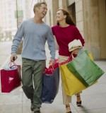 Couple on City Sidewalk with Shopping Bags Despesas dos consumidores estrangeiros em Portugal aumentaram nos últimos quatro meses de 2011